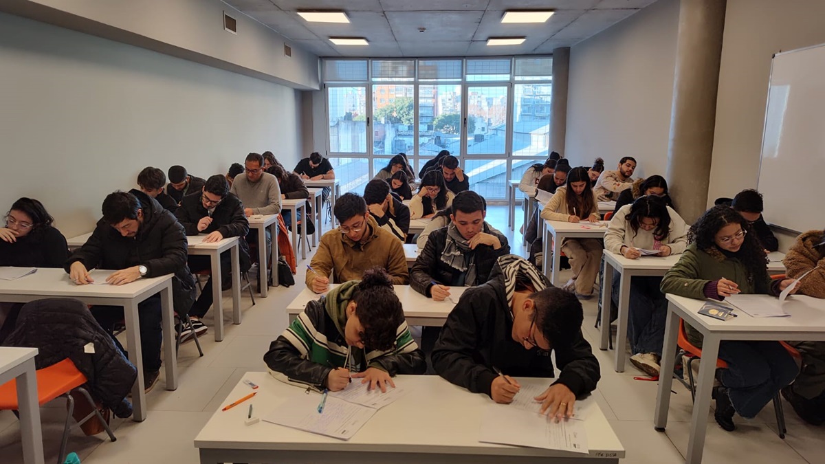 La imagen muetra una foto de estudiantes en un aula rindiendo el CEA en julio de 2024