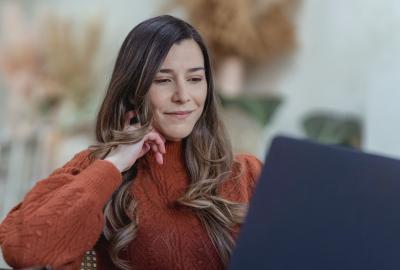 mujer mirando computadora sonriendo