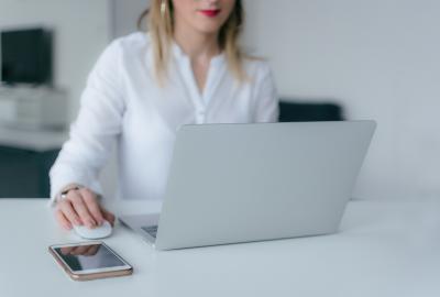 La imagen muestra a una mujer frente a una computadora