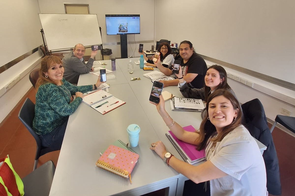 La imagen mestra una clase de idiomas en el Hospital Garrahan, estudiantes y profesor alrededor de una mesa