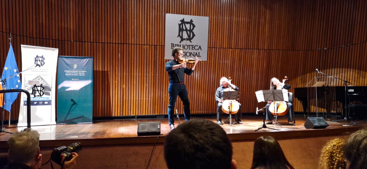 La imagen muestra una fotografía del evento en la Biblioteca Nacional