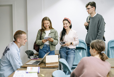 La imagen muestra a un grupo de estudiantes conversando